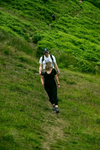 Two people walking through a green field