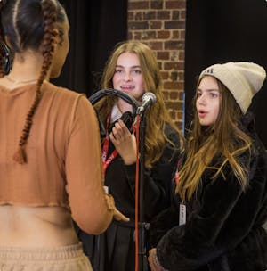Young people standing in front of microphones.