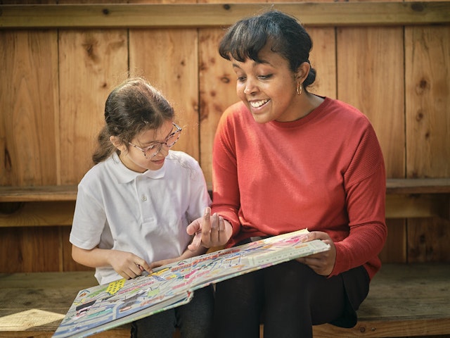 A child and a woman read together