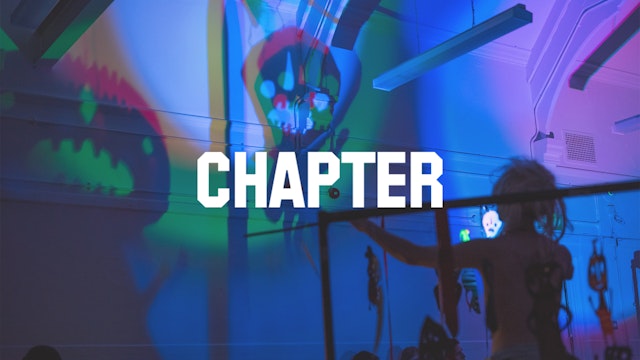 Chapter logo overlayed on an image of the interior of a gallery space with shadows cast by multi-coloured lights on the walls. The shadows appear alien in shape and the figure of a statue in the bottom left of the image appears to be looking up at the shadows.