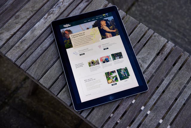 The Garden Organic website on a tablet device, on a garden bench