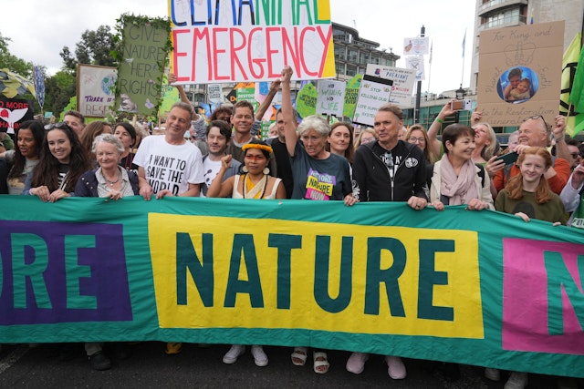 People, including Chris Packham, hold a banner at the Restore Nature Now march