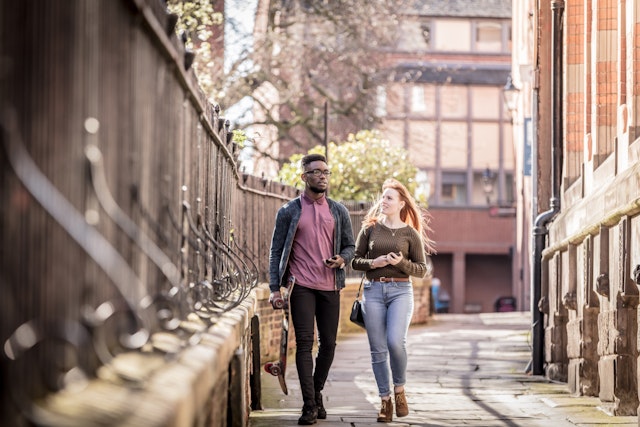 Two students walk down a cobbled street