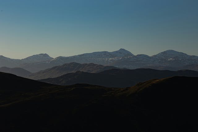 A landscape with hills and mountains in the back