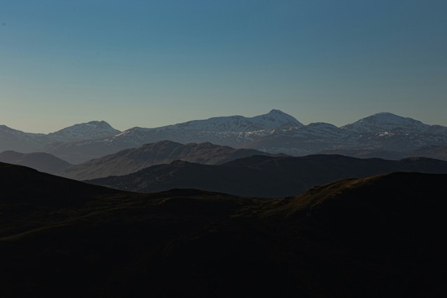 A landscape with hills and mountains in the back