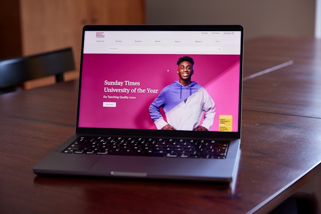 Sheffield Hallam University homepage on a laptop on a wooden table