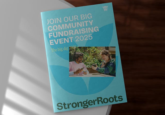 Bright blue StrongerRoots community event leaflet promoting “The Big Dig 2025” with a photo of two people smiling outdoors.