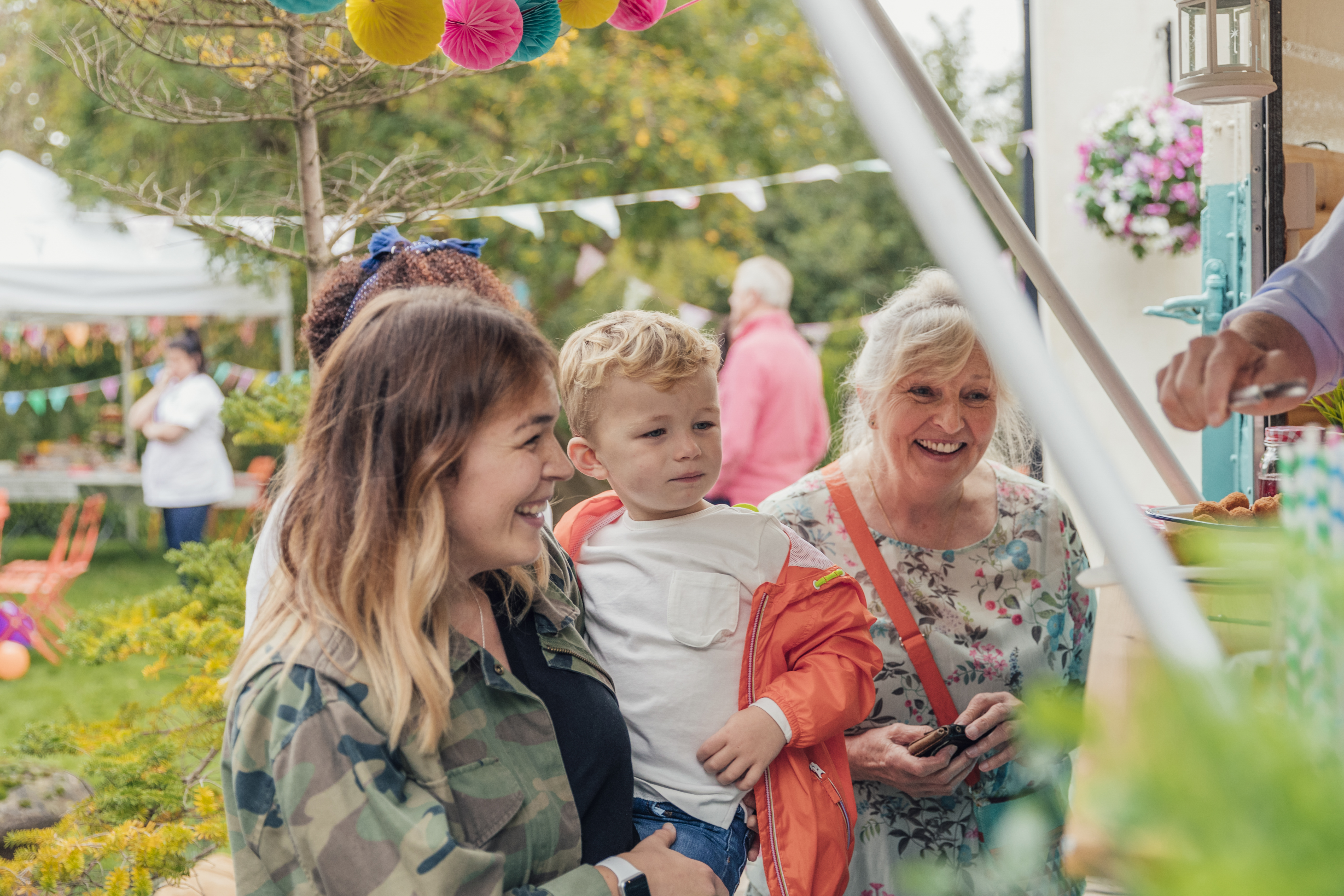 Family smiling at a community event surrounded by decorations, reflecting StrongerRoots’ focus on connection and inclusion.