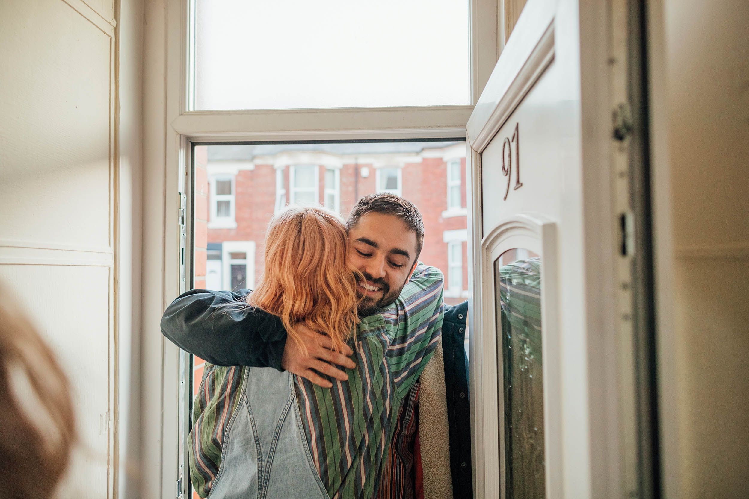 Two people hug in a door way