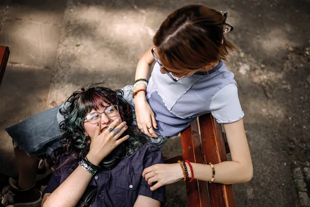 A young woman lying in her friends lap, laughing