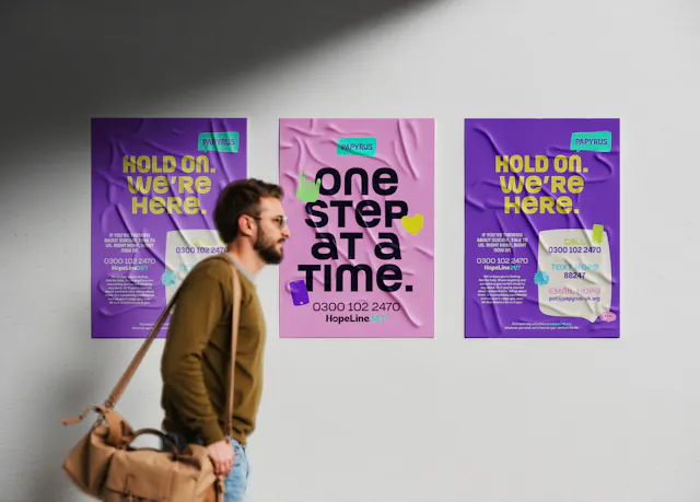 A man walking past 3 Papyrus posters